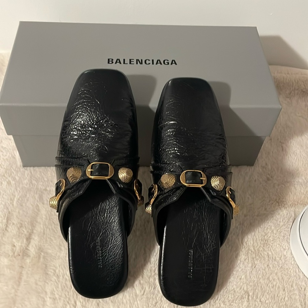 Balenciaga Black Leather Slipper Mules with buckle and textured finish.
